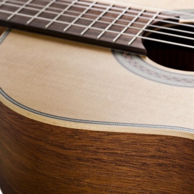 Parte da guitarra acústica com madeira clara e escura e cordas metálicas