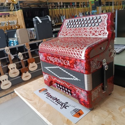 Acordeão vermelho detalhado com a marca ORGANOLA numa loja de instrumentos musicais
