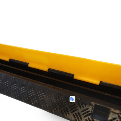 Barreira amarela plástica com encaixes pretos sobre superfície metálica texturada