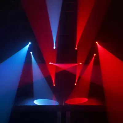 Holofotes emitindo luzes vermelhas e azuis em ambiente escuro