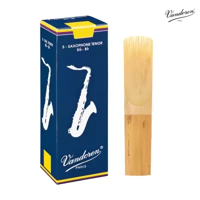 Palheta de madeira clara para saxofone tenor ao lado da embalagem azul da Vandoren