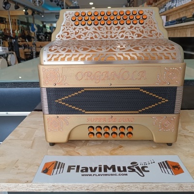 Acordeão dourado com botões laranja e texto gravado numa loja musical