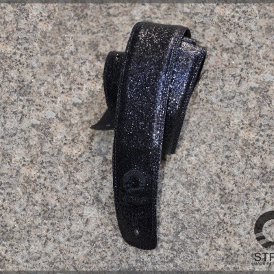 Correia preta brilhante para guitarra ou violão num fundo de granito cinza