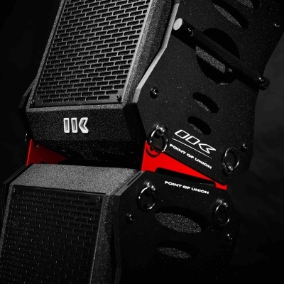 Coluna de áudio preta com textos e detalhes vermelhos sobre fundo preto.