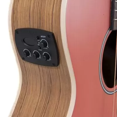 Guitarra acústica com painel de controlo preto embutido no lado de madeira clara e frente cor de salmão