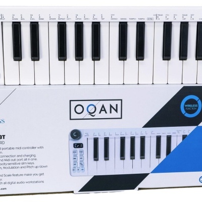 Teclado MIDI controlador QOAN com 25 teclas e roda preta em cima da caixa branca com azul