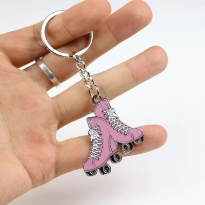 Chaveiro patins de rodas rosa em mão