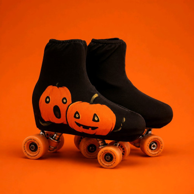 Patins de quatro rodas com capa preta e abóboras laranja desenhadas