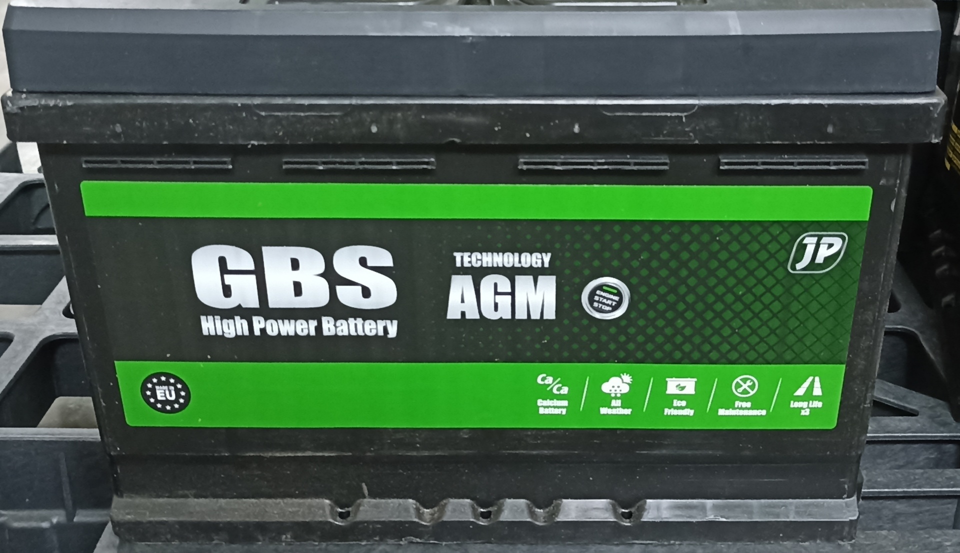 Bateria de carro preta com etiqueta verde e preta