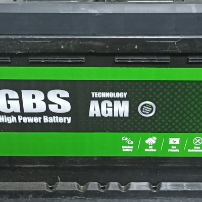 Bateria de carro preta com etiqueta verde e preta