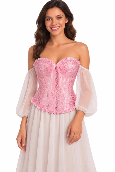 Corset rosa de padrão floral com fecho frontal, usado com blusa branca de mangas bufantes e saia fluida branca.