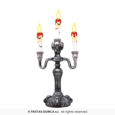 Castiçal preto com três velas brancas e detalhes de caveiras
