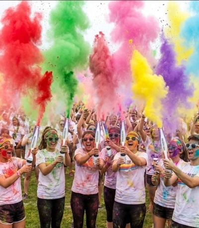 Grupo com pó colorido a ser lançado ao ar em evento ao ar livre