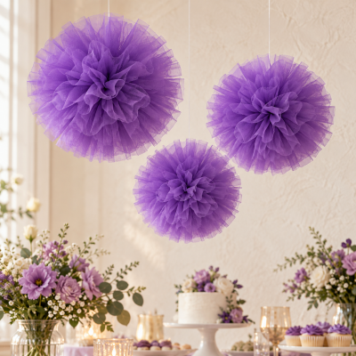 Bolas decorativas roxas penduradas em tule com mesa decorada ao fundo