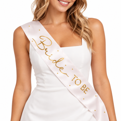 Faixa rosa claro com texto dourado Bride TO BE usada sobre vestido branco