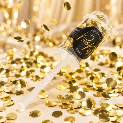 Spray com confetti dourado sobre superfície com confetti espalhado