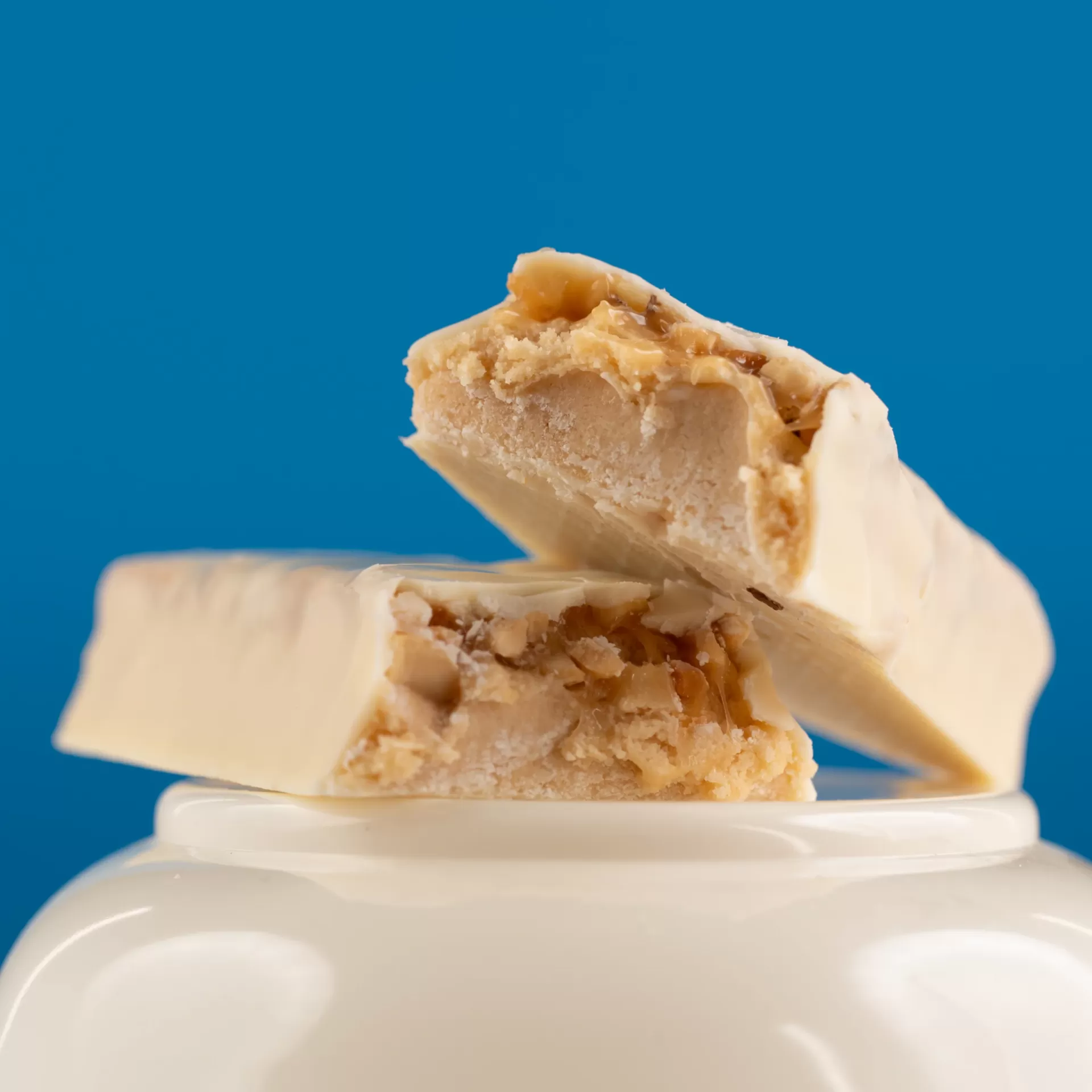 Barra ou snack coberto de branco partido ao meio com recheio claro