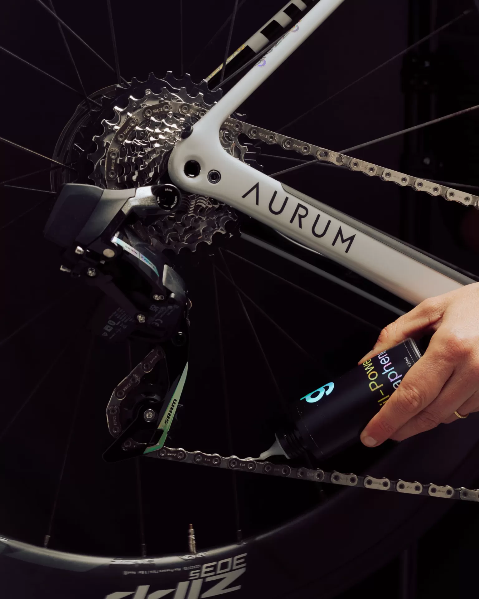 Bicicleta branca Aurum com corrente, engrenagens metálicas e aplicação de óleo na corrente