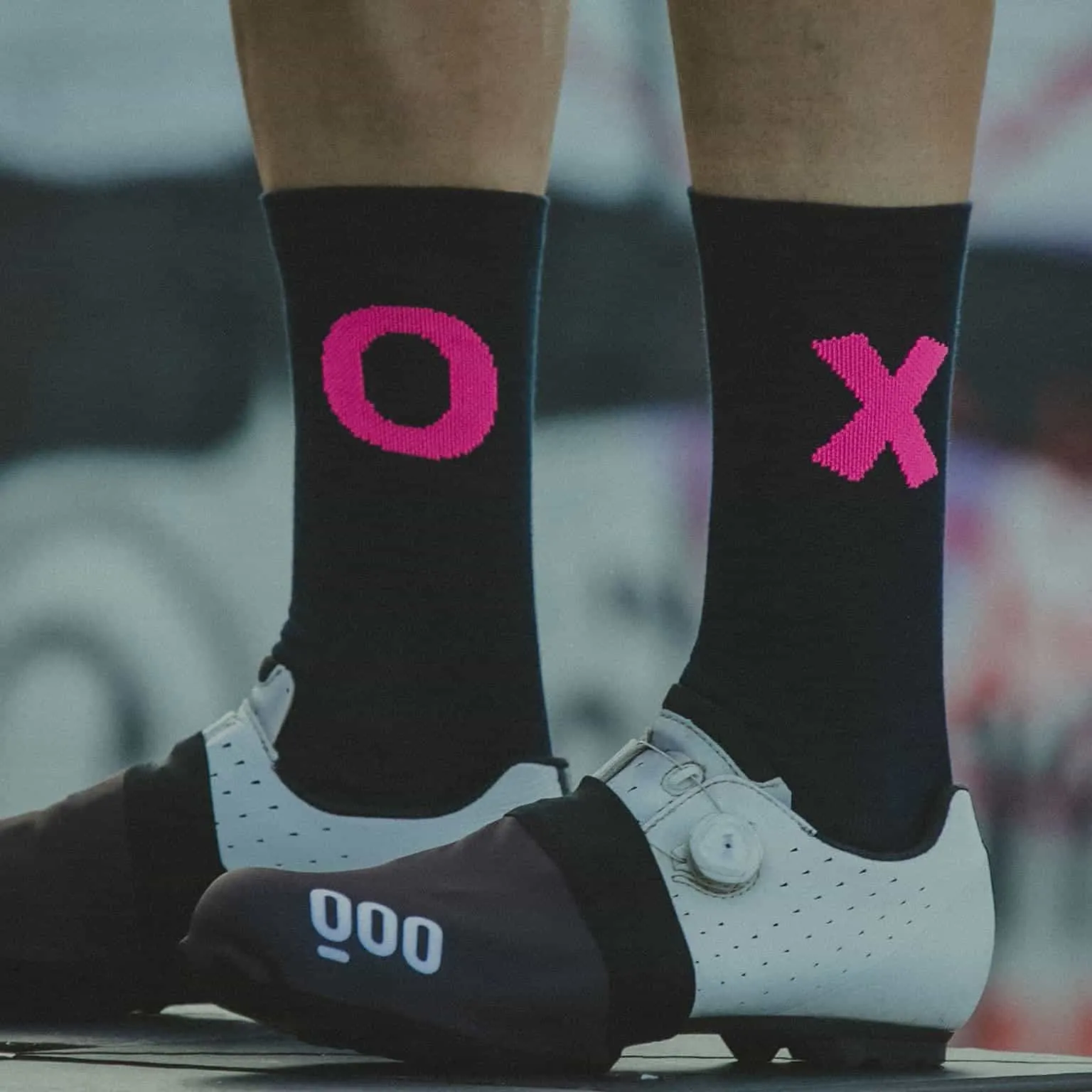 Meias pretas com O e X rosa e sapatos de ciclismo brancos e pretos