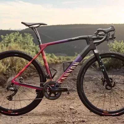 Bicicleta Canyon de estrada colorida com quadro vermelho, roxo e preto em trilho de terra