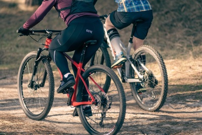Duas bicicletas de montanha com ciclistas em terreno de terra batida.