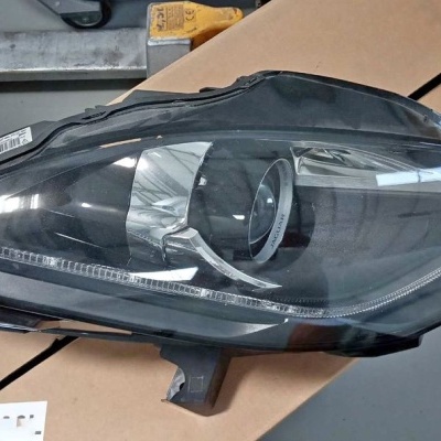 Farol automóvel preto e transparente sobre superfície de cartão