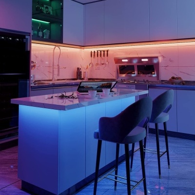 Cozinha moderna com ilha iluminada por luzes LED azuis e móveis brancos