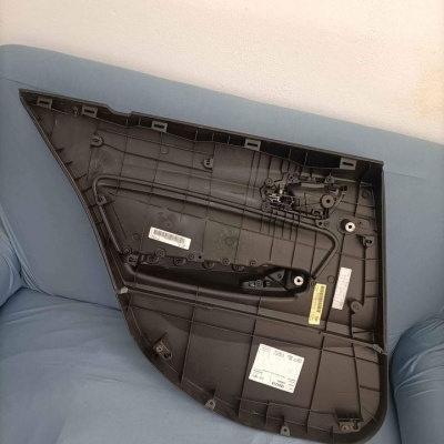 Painel interior traseiro de porta de automóvel de plástico preto sobre sofá azul