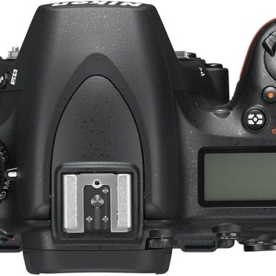 Vista superior de uma câmara digital reflex preta com mostrador LCD e botões de controlo