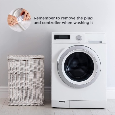 Máquina de lavar roupa branca e cesto de roupa de vime com texto informativo na parede.