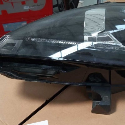 Farol dianteiro de carro em plástico transparente e preto sobre cartão