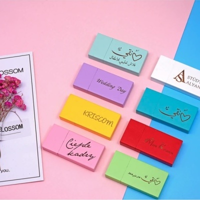 Cartões coloridos com textos diversos junto a um ramo seco de flores rosa