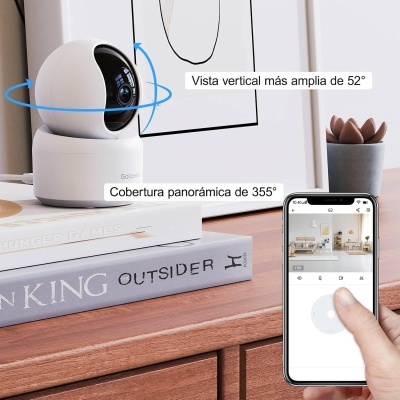 Câmara de vigilância branca sobre livros numa superfície de madeira com controlo por smartphone