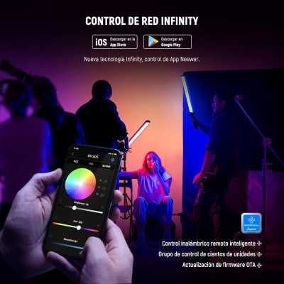 Pessoa segurando smartphone com app de controlo de luz, cena com equipamento de iluminação e pessoa sentada em fundo colorido azul rosa