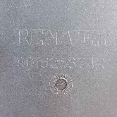 Superfície cinzenta com texto gravado Renault e número de identificação