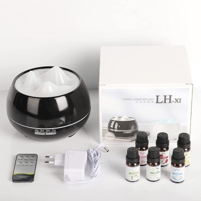 Difusor de aroma preto e branco com seis frascos de óleos essenciais, comando à distância e carregador, sobre fundo branco.