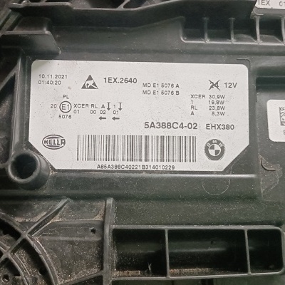 Elemento automóvel preto com etiqueta branca e códigos técnicos