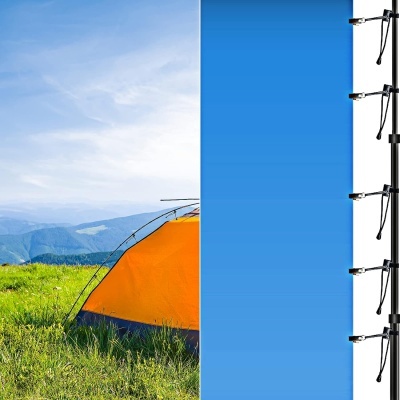 Tenda laranja num campo verde com céu azul e microfones em tripés numa parede azul