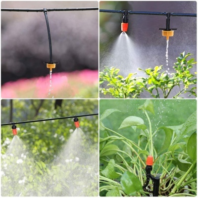 Aspersores de irrigação em tubo preto a regar plantas com bocais vermelhos e amarelos