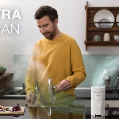 Homem a cozinhar numa cozinha com dispositivo branco e texto ULTRA CLEAN