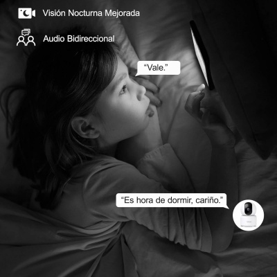Criança deitada na cama a olhar para um tablet iluminado com textos em espanhol e ícone de uma câmara branca.