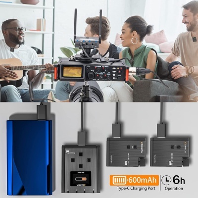 Dispositivos eletrónicos para gravação, incluindo power bank azul metálico e carregadores de bateria com indicação 600mAh e operação de 6h, em ambiente de gravação com pessoas ao fundo.
