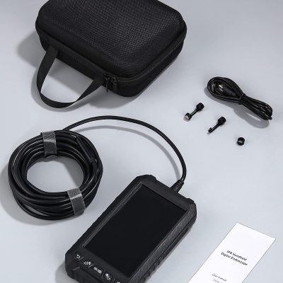 Dispositivo eletrônico portátil com acessórios e capa preta sobre superfície clara