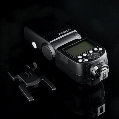 Flash de câmara fotográfica TTE802 preto com suporte em superfície preta