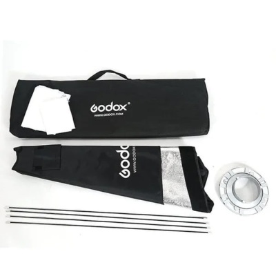 Conjunto de iluminação Godox com bolsa preta, softbox preto e branco com interior prateado, ródio metálico e quatro hastes.