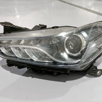 Farol de automóvel em plástico transparente com refletor interno e projetor redondo.