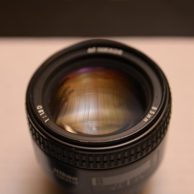 Lente de câmera fotográfica Nikkor 50mm preta sobre superfície branca