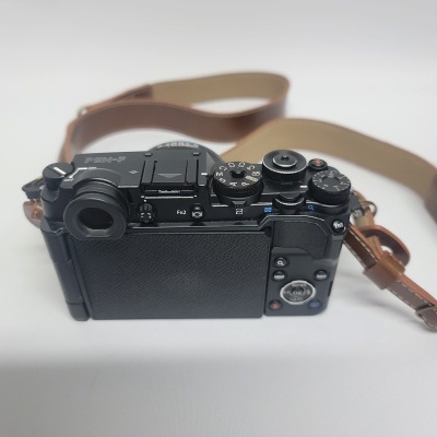 Câmara fotográfica PEN-F preta com alça de couro castanha