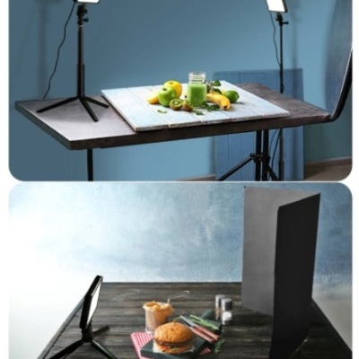 Setup de fotografia com luzes LED em tripés, frutas com smoothie, e hambúrguer com batatas em mesas diferentes