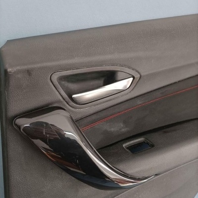 Painel interior de porta de automóvel preto com puxador cromado e costura vermelha